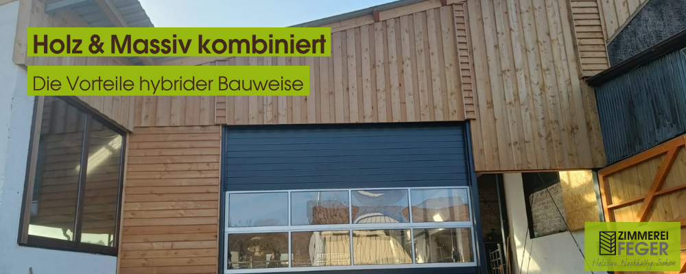 Frontansicht eines Gebäudes in hybrider Bauweise: Massive Bauteile aus Beton und Mauerwerk im unteren Bereich, kombiniert mit einer modernen Holzfassade im oberen Bereich. Große Fensterflächen und ein Sektionaltor deuten auf eine Gewerbe- oder Lagernutzung hin. Die Fassade zeigt den fließenden Übergang zwischen Massiv- und Holzbau. In der linken Bildhälfte reflektieren Fenster die umliegende Umgebung