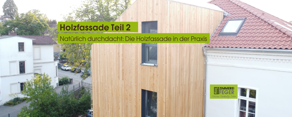 Das Foto zeigt die Giebelseite eines Hauses mit einer vertikal verschalten Holzfassade aus hellem, naturbelassenem Holz. Links im Bild ist die Nachbarbebauung erkennbar, rechts schließt sich ein saniertes Bestandsgebäude mit weißem Putz und rotem Ziegeldach an. Unten rechts befindet sich das Logo der Zimmerei Feger mit dem Claim „Holzbau. Nachhaltig. Schön.“. In das Bild eingeblendet ist ein grüner Infoblock mit der Aufschrift: